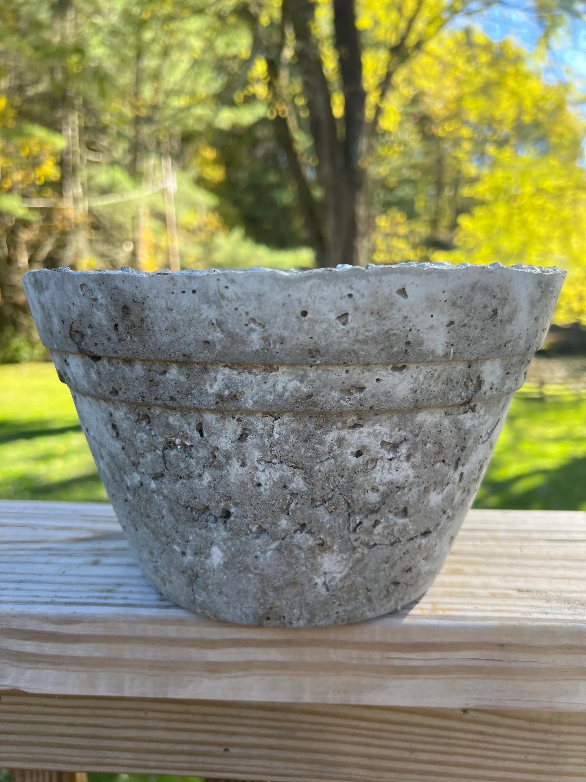 Concrete pot on a wooden surface with a natural background