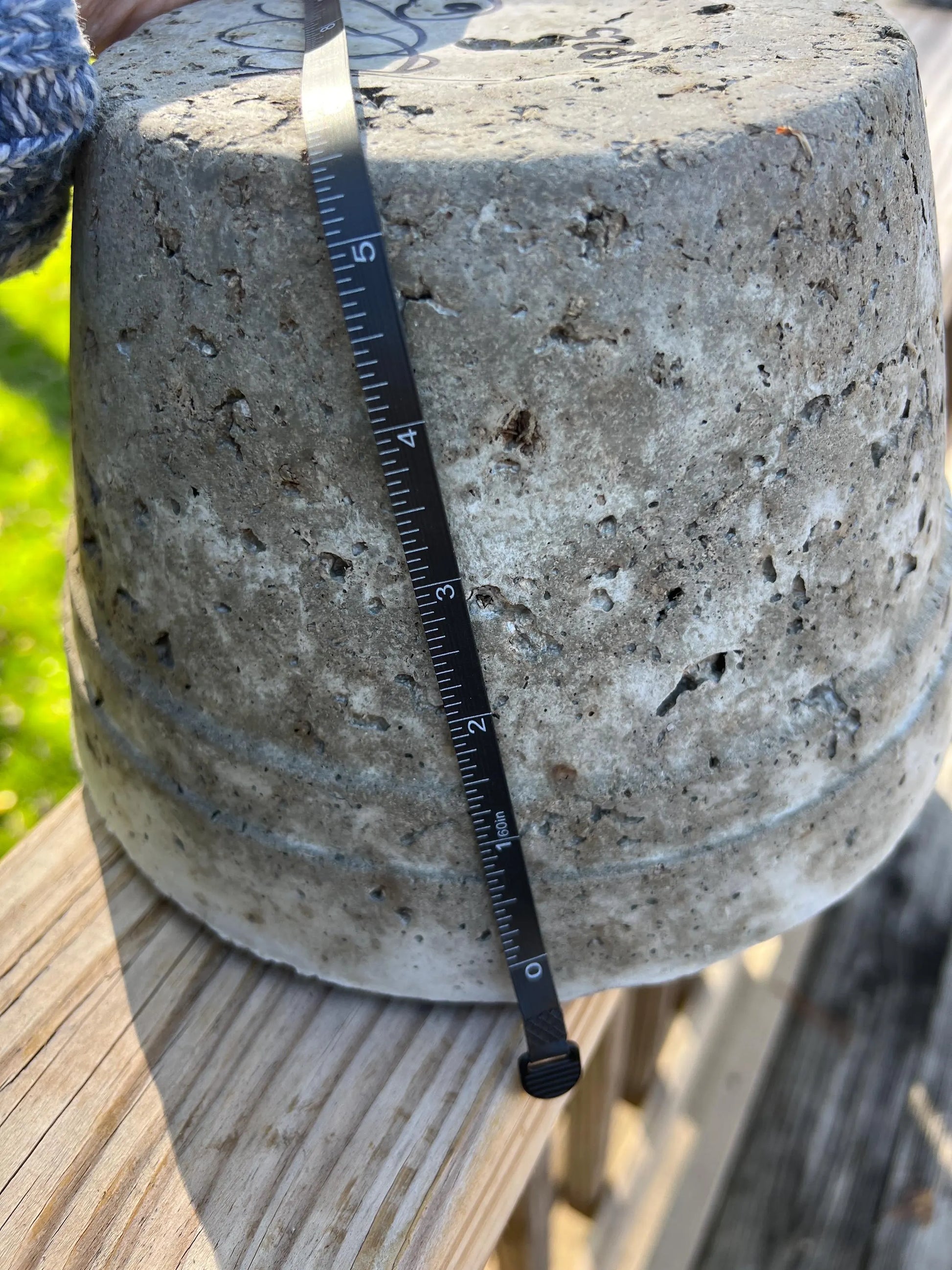 Concrete block with a ruler for scale on a wooden surface