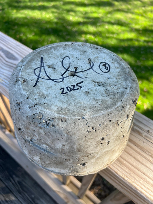 Concrete block with a signature and year on a grassy background