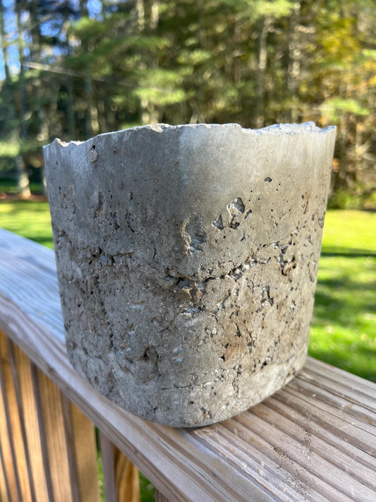 Concrete pot on a wooden surface with a natural background